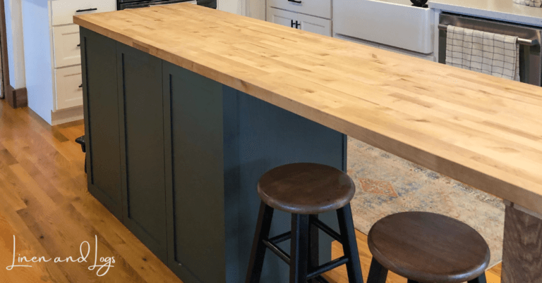 dark green kitchen island with wood butcher block countertop