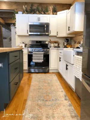 dark green cabinet with wood countertop with white kitchen cabinets