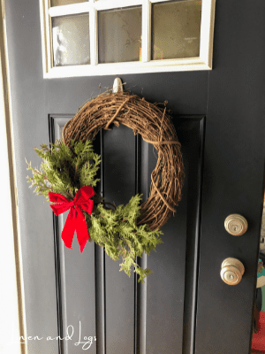 cedar grapevine wreath with red bow on black door