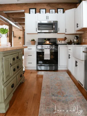 green cabinet with wood counter near white cabinets with white counter