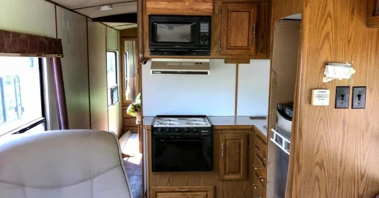 before reno picture of class a motorhome with old flooring, wood cabinets